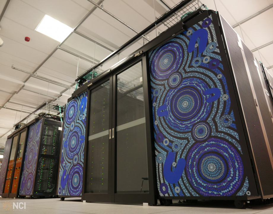 Tall panels decorated with blue Aboriginal artwork separated by sliding glass doors, seen from below.