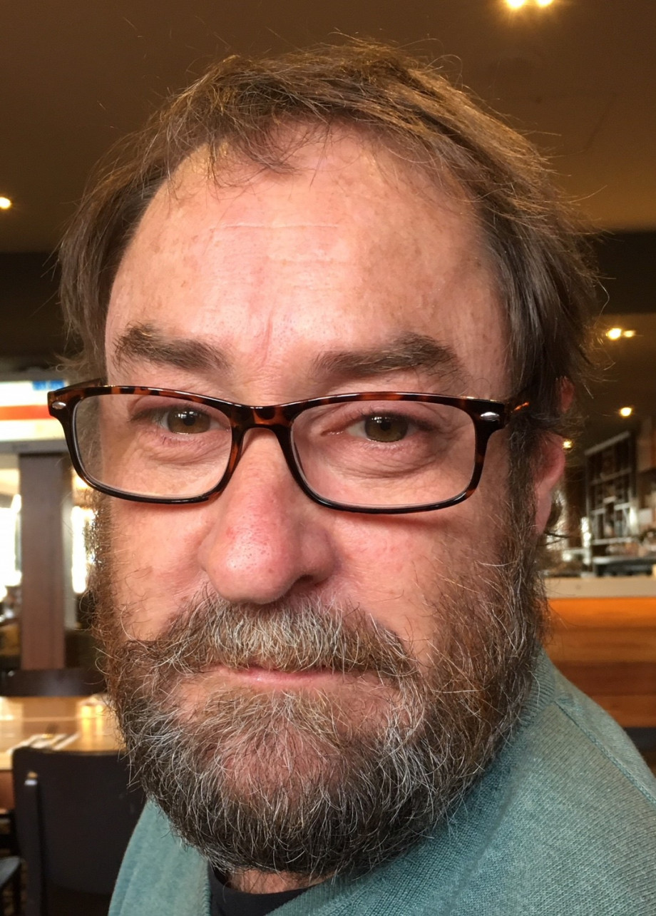 Close up photo of a bearded man looking straight at the camera.