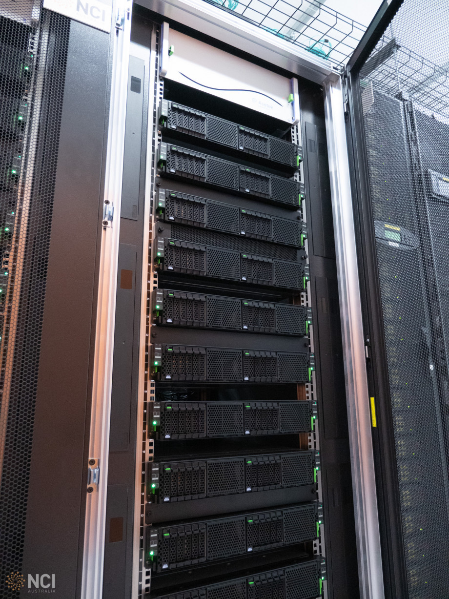 A tall stack comprising of around a dozen black and green computer servers.