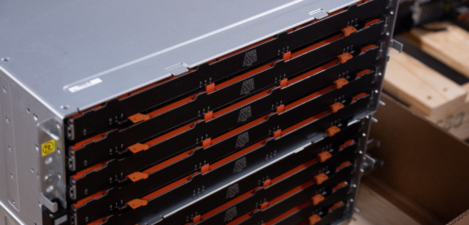 A silver box with a black front arranged in rows with orange highlights, this is a server that stores hard drives.