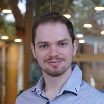 A close up headshot of a man looking at the camera.