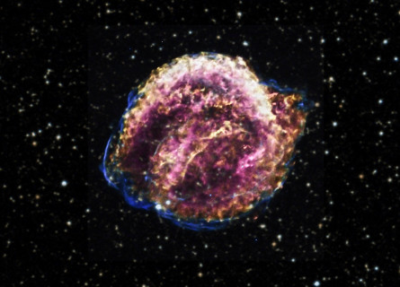 A purple, gold and pink ball of gas on a fuzzy black sky background filled with stars.