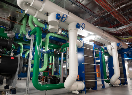 A complex series of green, blue and white pipes connected to tall blue and grey machines.